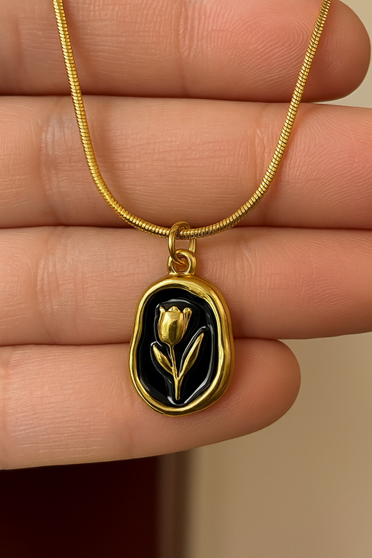 Stainless steel gold necklace with a black enamel base and a delicate tulip design